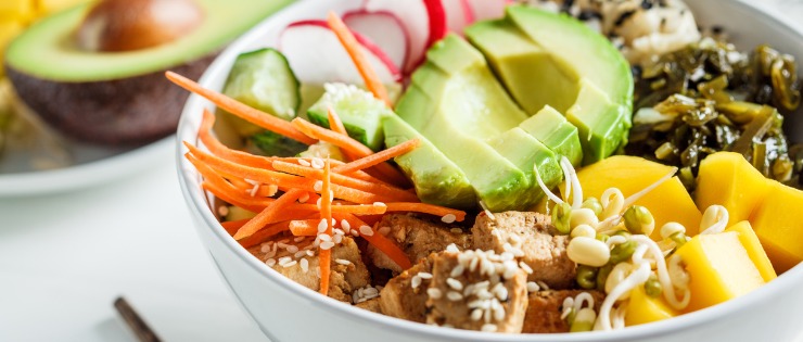 Poke bowl of healthy, unprocessed foods including vegetables, tofu and avocado.