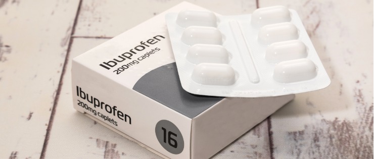A packet of ibuprofen painkiller medicine on the wooden floor.