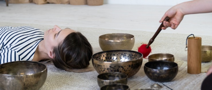 A woman lying down in relaxation while receiving sound bath meditation.