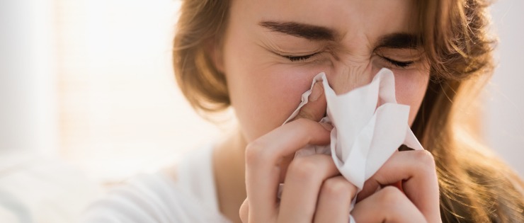 woman with histamine allergies blowing her nose