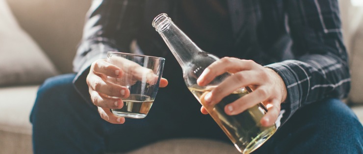 Man pouring an alcoholic drink, too much alcohol consumption can lead to chronic disease