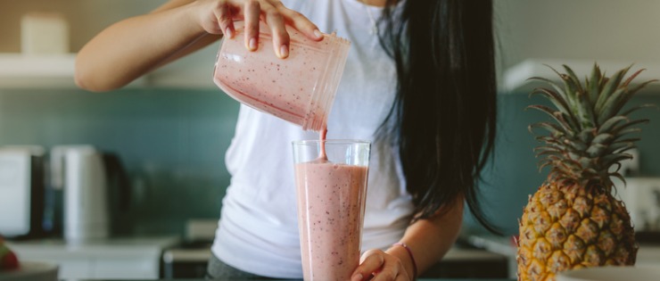 Young healthy female making a collagen supplement smoothie