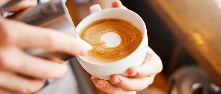 A barista making a cup of coffee - caffeine is a common food intolerance for many.