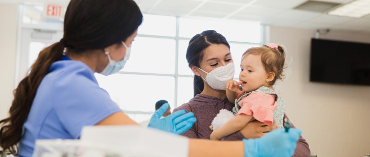 A nurse speaking to a mum and her child at an Urgent Care clinic