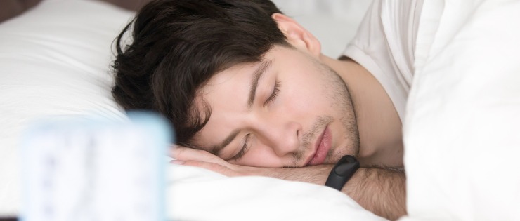 Man sleeping while wearing his fitness tracker.
