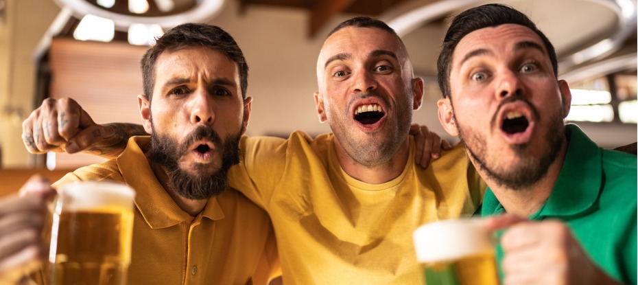 Australian footy fans watching a match while drinking local beer