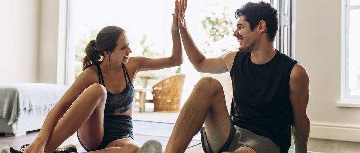  A young couple giving each a high-five after exercising