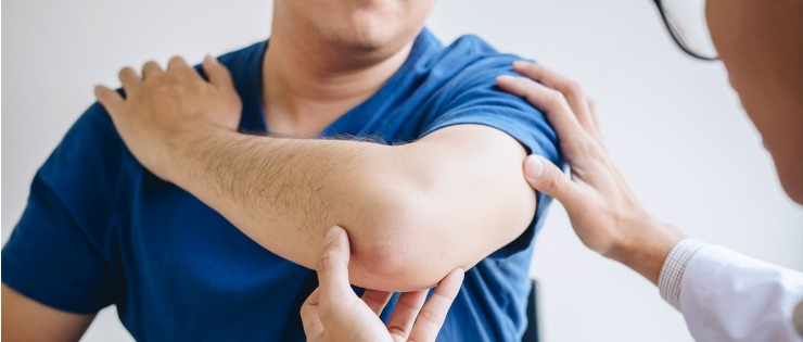 Male physiotherapist examining a patients elbow