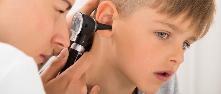 Doctor examining a childs ear for glue ear