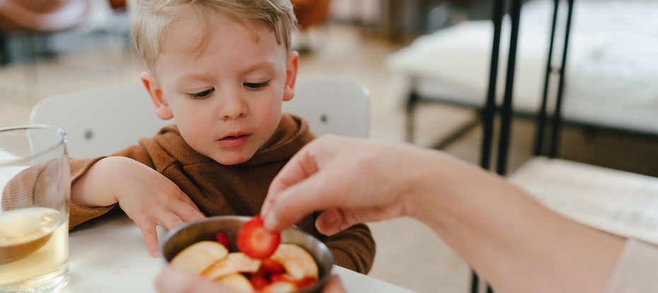 parent encouraging healthy habits for kids by introducing fruit to his boy