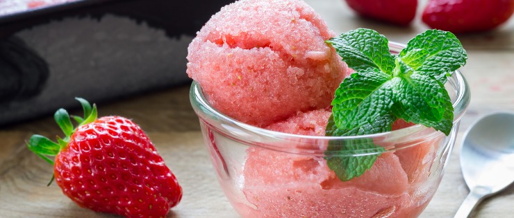 Strawberry and banana healthy ice cream in a bowl with mint to garnish.