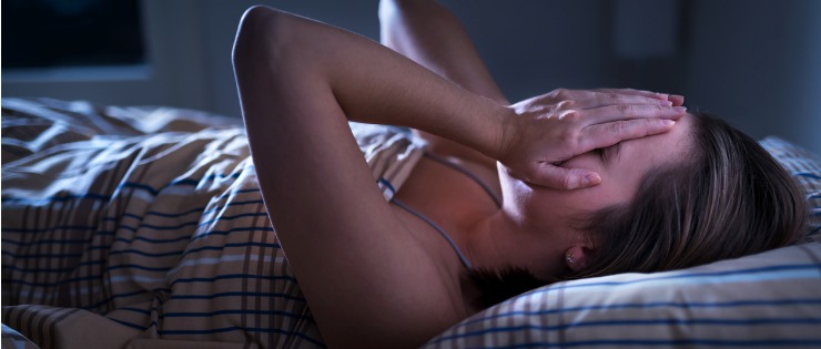 Woman laying in bed at night suffering from parasomnia.