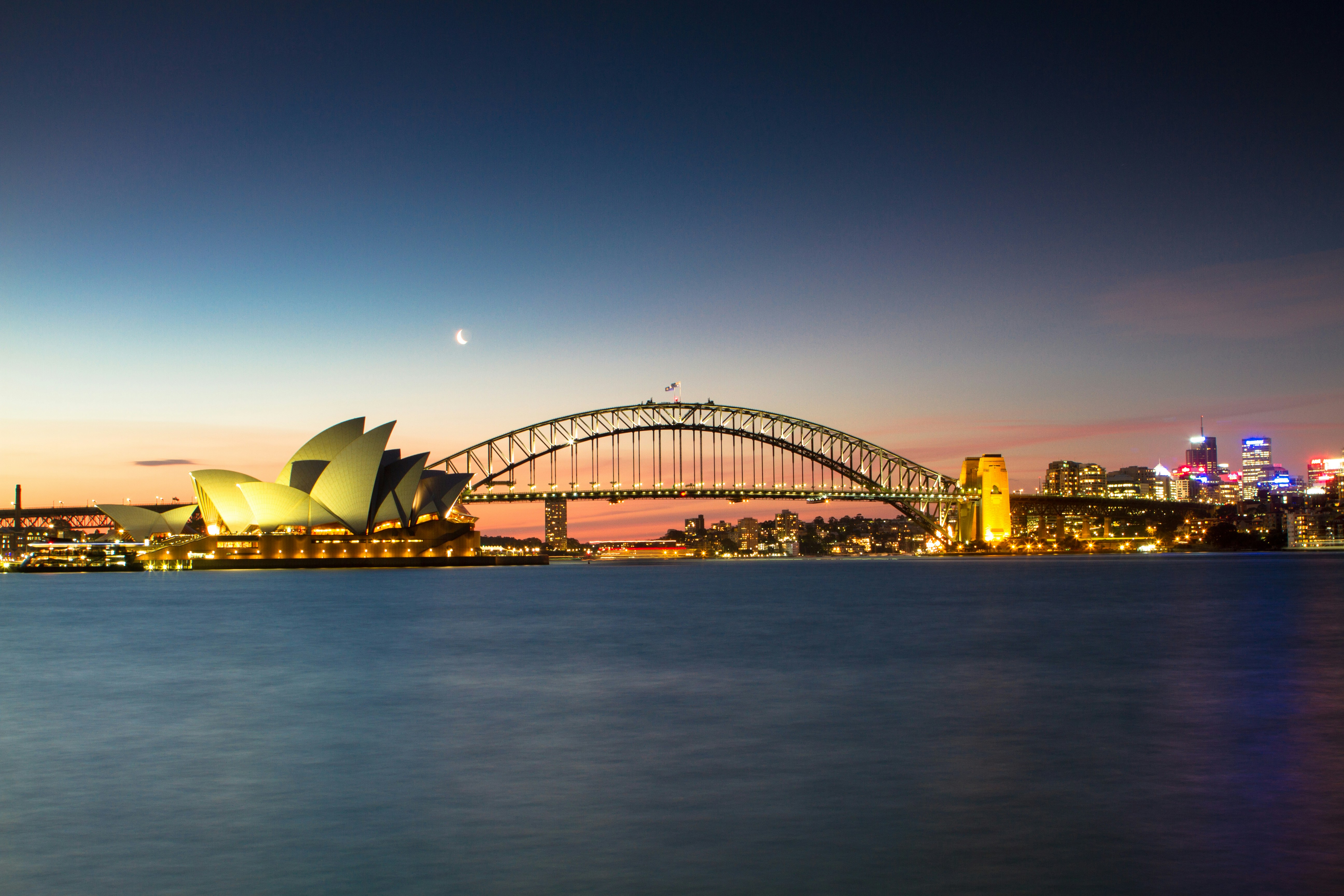 Sydney Opera House and Sydney Harbour Bridge at dusk, representing Australia travel, overseas visitors and working visa life in Australia.