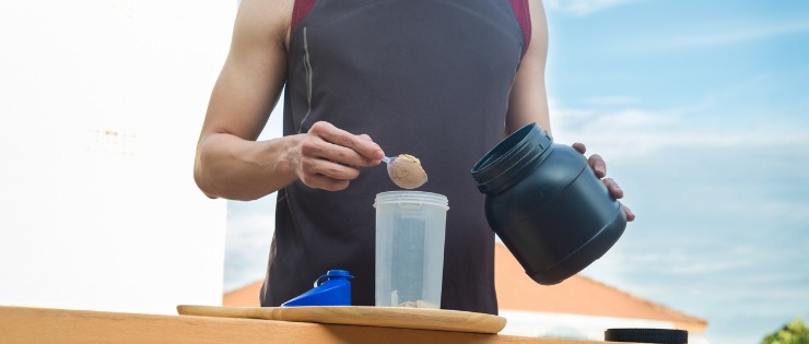 A man making a protein shake after a workout. 