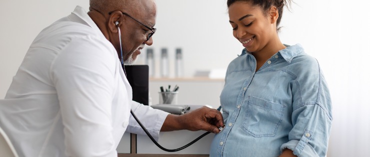 Male experienced obstetrician examining young pregnant woman