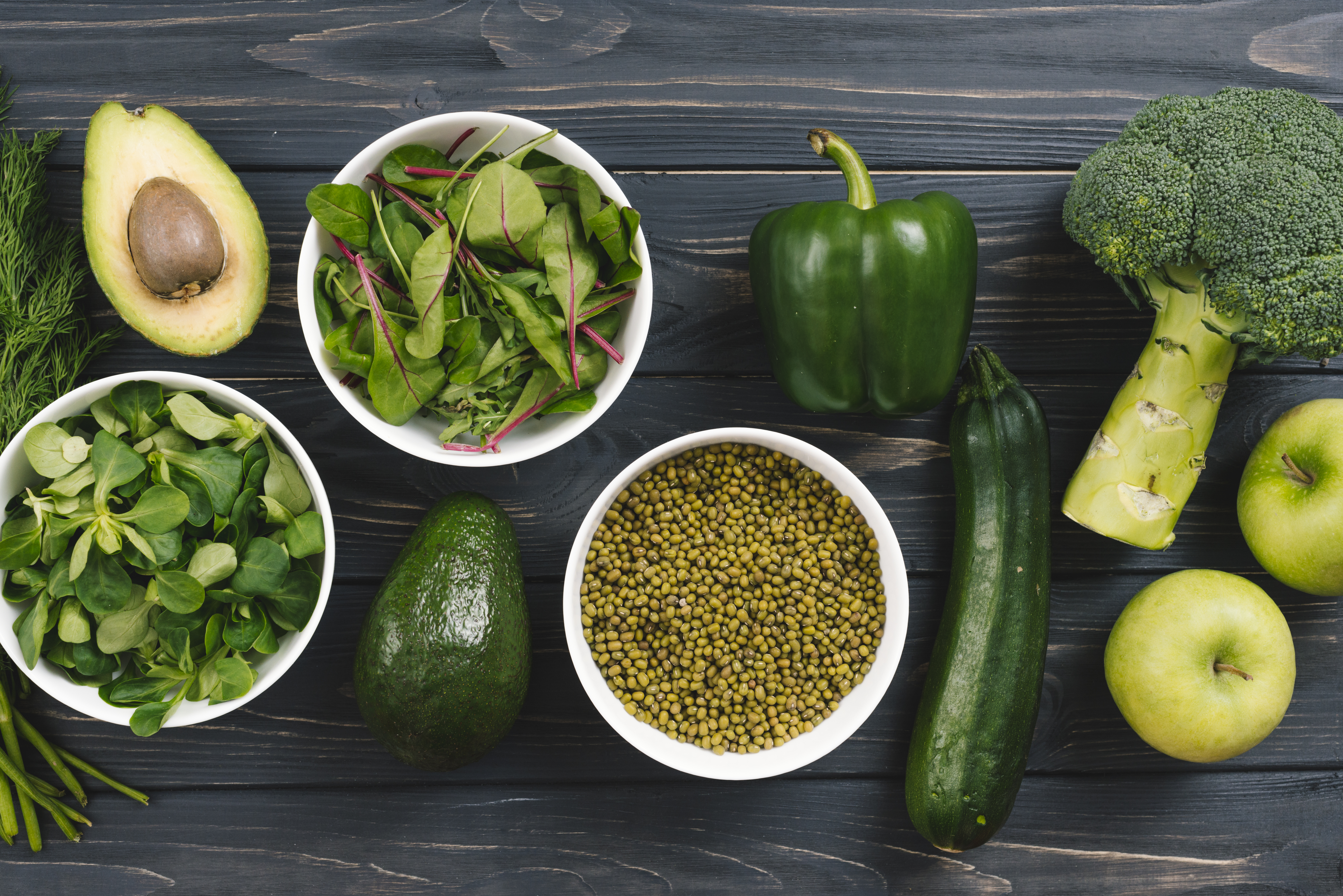 Green vegetables and lentils on a wooden counter top