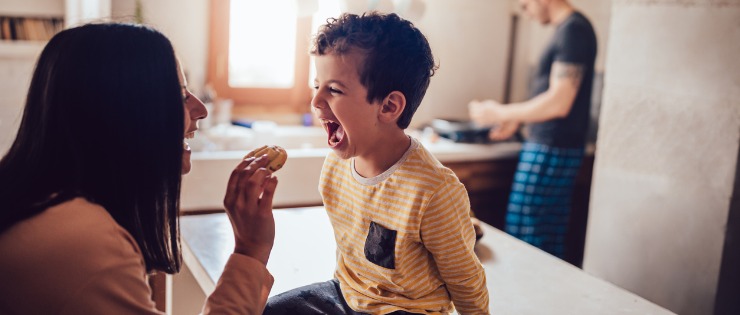 Mother rewarding her son with a cookie after being well-behaved