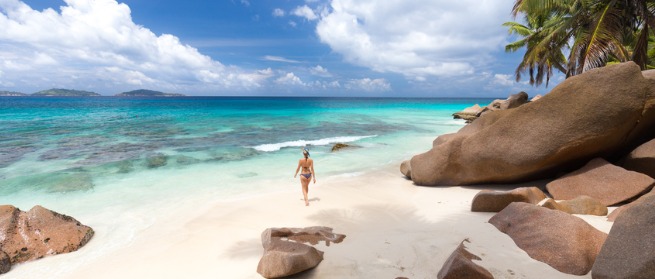 A woman walking along a tropical beach